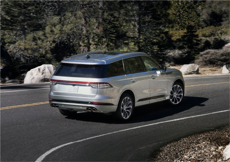 A 2023 Lincoln Aviator® Grand Touring model is shown being driven on a tight turn of a mountain road | Ted Britt Chantilly Lincoln in Chantilly VA