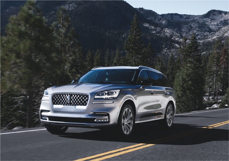 A 2023 Lincoln Aviator® Grand Touring SUV being driven on a winding road to demonstrate the capabilities of all-wheel drive | Ted Britt Chantilly Lincoln in Chantilly VA