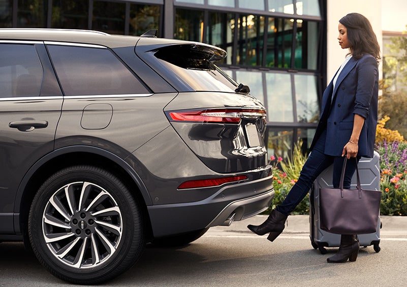 A woman with her hands full uses her foot to activate the available hands-free liftgate. | Ted Britt Chantilly Lincoln in Chantilly VA
