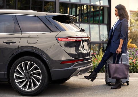 A woman with her hands full uses her foot to activate the available hands-free liftgate. | Ted Britt Chantilly Lincoln in Chantilly VA