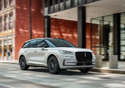 The 2024 Lincoln Corsair® SUV with the Jet Appearance Package and a Pristine White exterior is parked on a city street. | Ted Britt Chantilly Lincoln in Chantilly VA