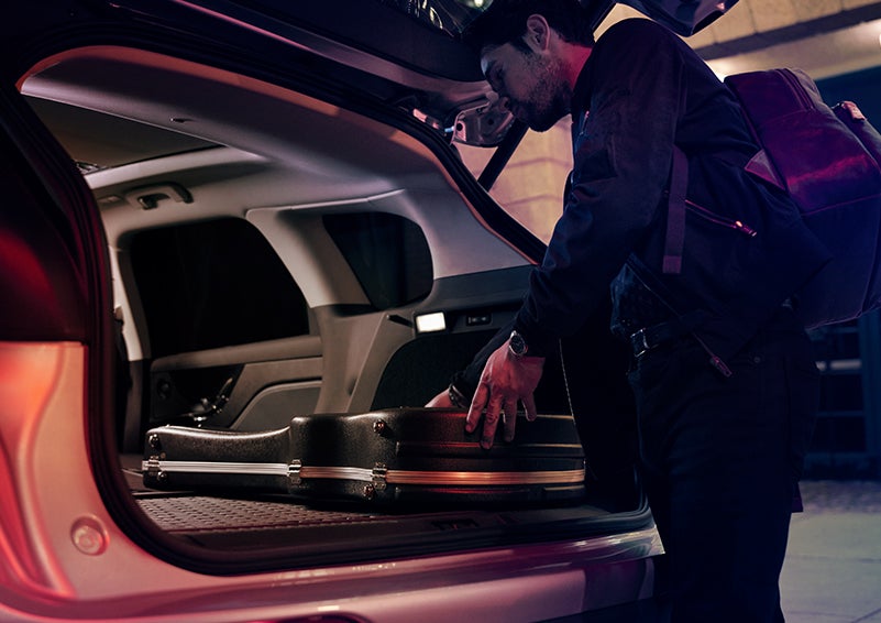 A man is shown loading cargo into the rear of a 2024 Lincoln Corsair® SUV with the second-row seats folded flat. | Ted Britt Chantilly Lincoln in Chantilly VA