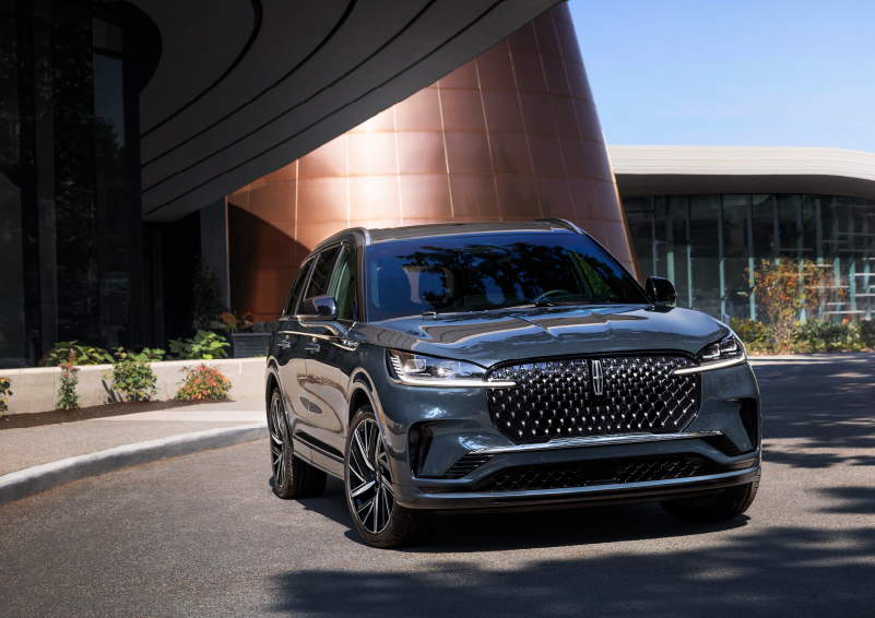 A gray 2025 Lincoln Aviator® SUV is parked outside a modern building with the sun shining. | Ted Britt Chantilly Lincoln in Chantilly VA