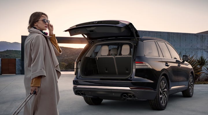 A woman approaches a 2026 Lincoln Aviator® SUV with its rear liftgate open. | Ted Britt Chantilly Lincoln in Chantilly VA
