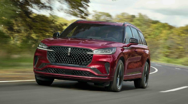 A 2027 Lincoln Aviator® SUV is being driven on a country road | Ted Britt Chantilly Lincoln in Chantilly VA